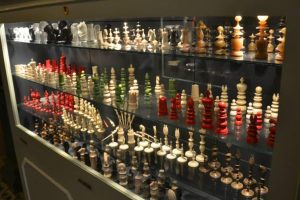 Cassa Rocca Piccola's chess collection on display inside the palace. Red, white and black colored pieces inside a lit up glass cabinet.