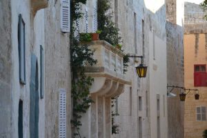 A balcony in Mdina with greenery spilling over the top
