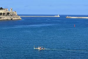 The Grand Harbour entrance with a water taxi crossing it